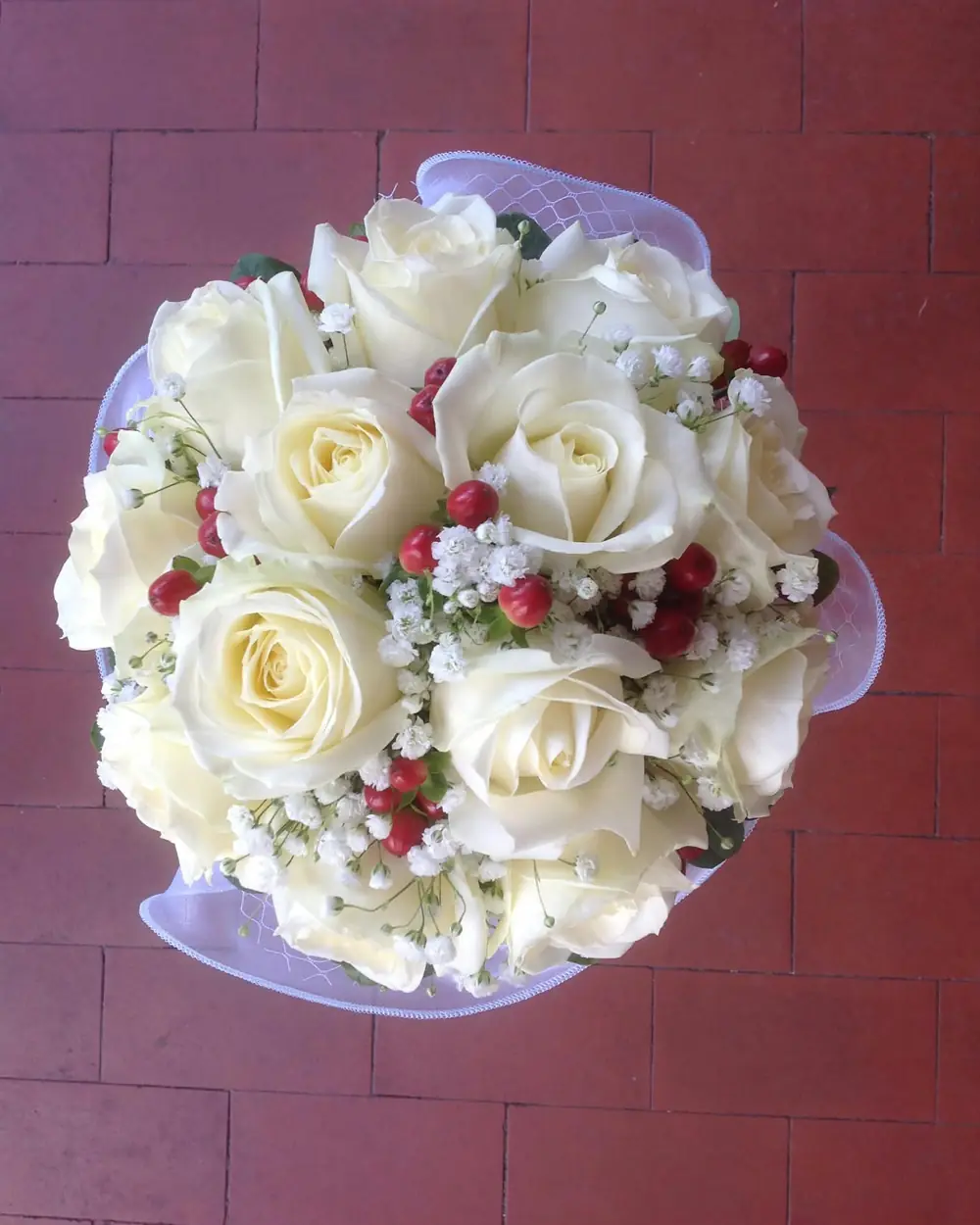 Bouquet di rose bianche con gypsophila e bacche rosse